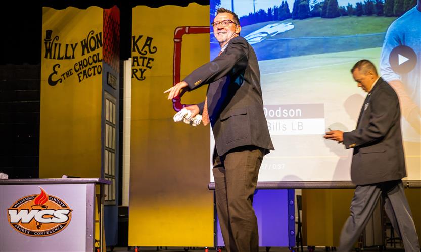 Man in suit throws t-shirt from stage